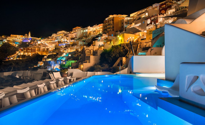 Athina Luxury Suites infinity pool overlooking Santorini caldera at sunset Greece