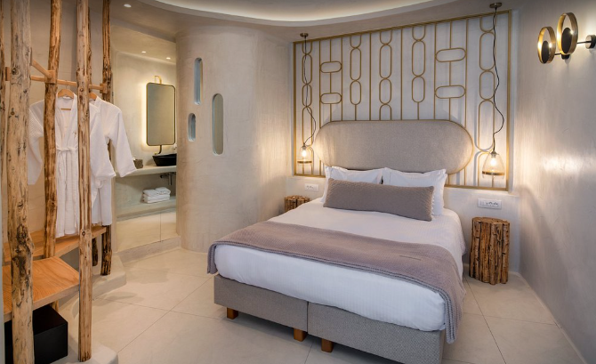 Athina Luxury Suites infinity pool overlooking Santorini caldera at sunset Greece