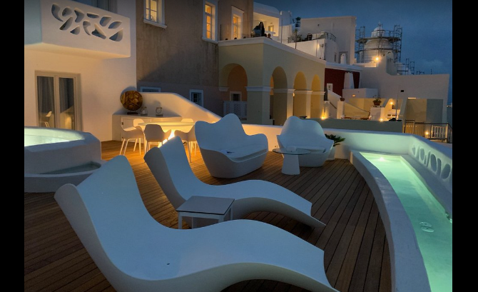 Athina Luxury Suites infinity pool overlooking Santorini caldera at sunset Greece